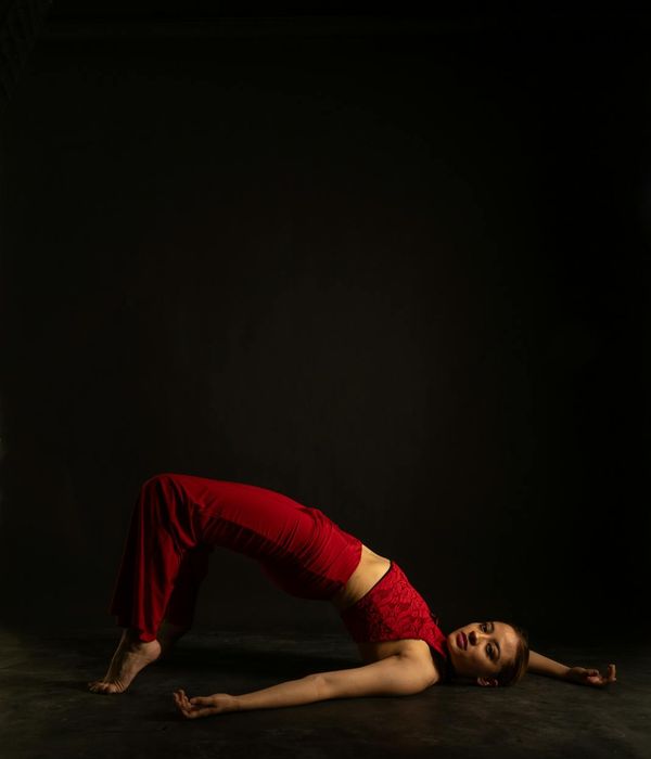 Woman performing graceful yoga movement in dark studio setting